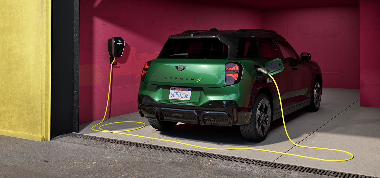 Garaže įkraunamo visiškai elektrinio MINI Aceman žalios British Racing Green spalvos vaizdas iš arti