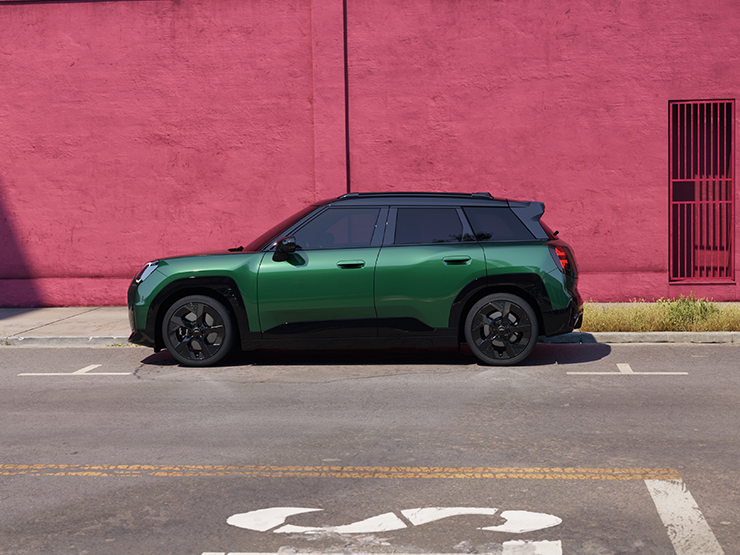 Žalios British Racing Green spalvos visiškai elektrinio MINI Aceman vaizdas iš šono su juodos spalvos stogu