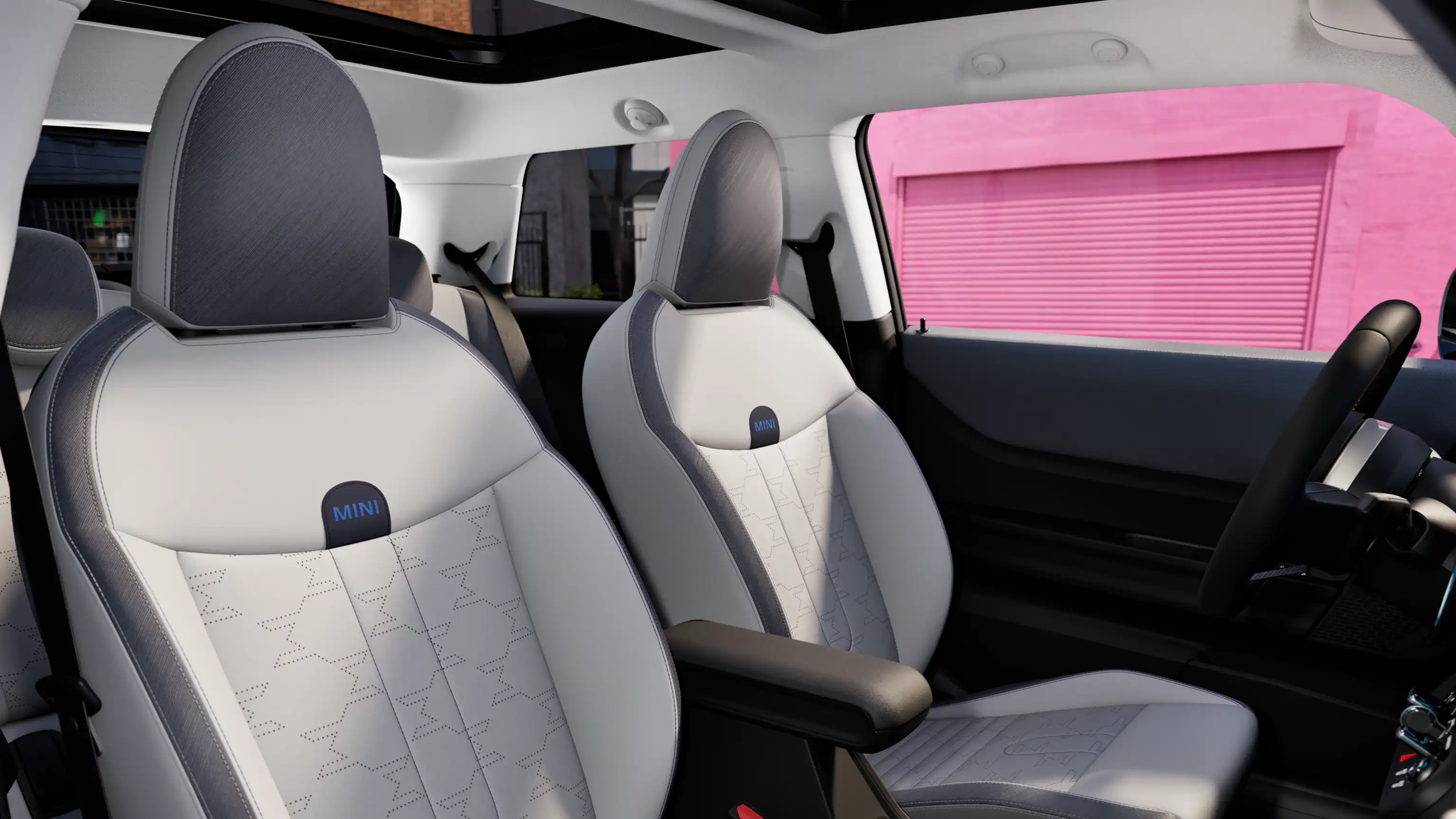 MINI Cooper interjeras su prietaisų skydeliu, vairu, apvaliu ekranu, panoraminiu stikliniu stoglangiu ir priekinių sėdynių atlošais.