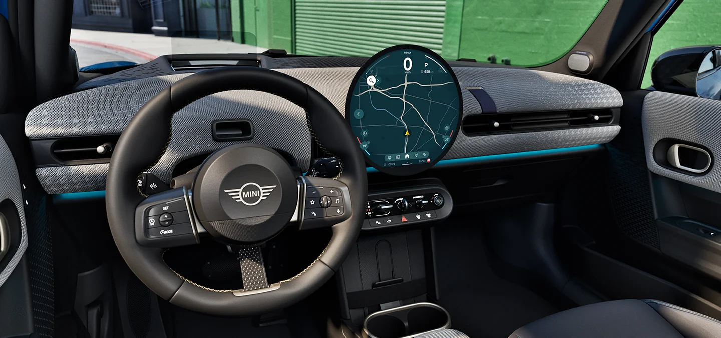 MINI Cooper 5-durio interjero vaizdas su  valdymo skydeliu, vairu ir interaktyviuoju valdymo ekranu.