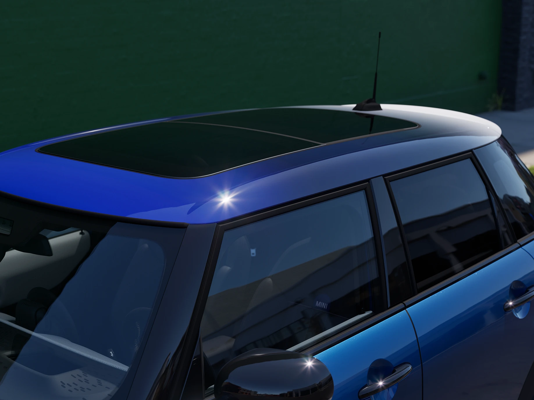 MINI Cooper 5-durio vaizdas iš arti su daugiatoniu mėlynu stogu.