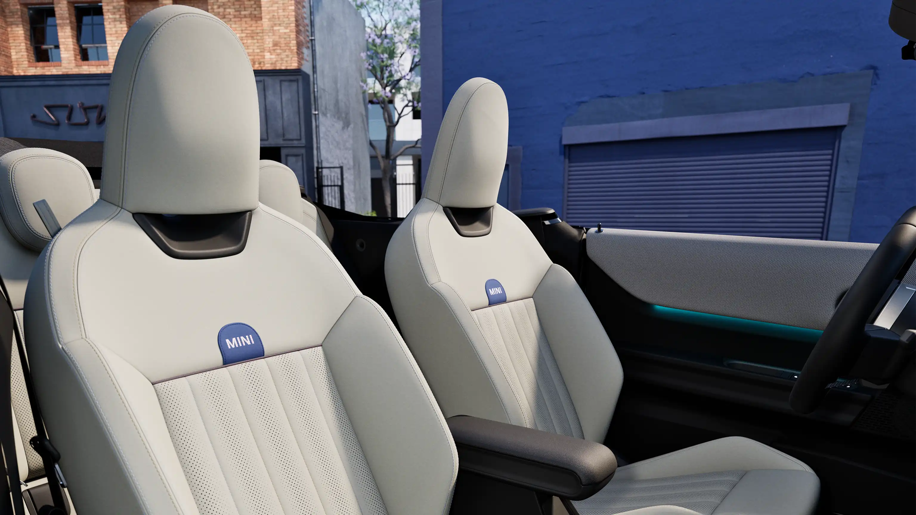 MINI Cooper kabrioleto interjero vaizdas su prietaisų skydeliu, vairu, apvaliu ekranu ir priekinių sėdynių atlošais.