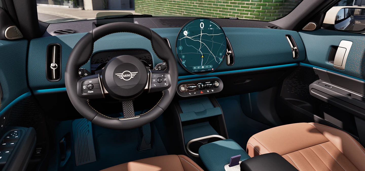 MINI Countryman salono vaizdas iš šono su prietaisų skydeliu ir vairu.