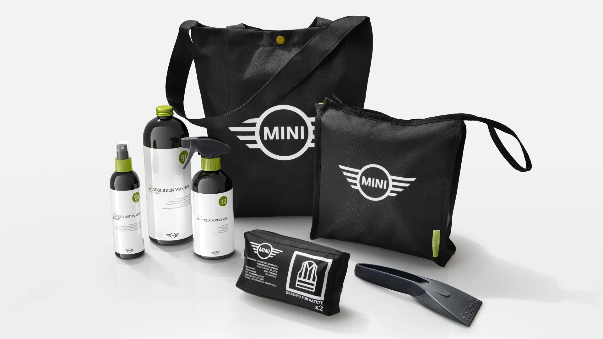 MINI automobilio priežiūros rinkinio valymo priemonių asortimentas MINI prekės ženklu pažymėtuose juoduose krepšiuose.