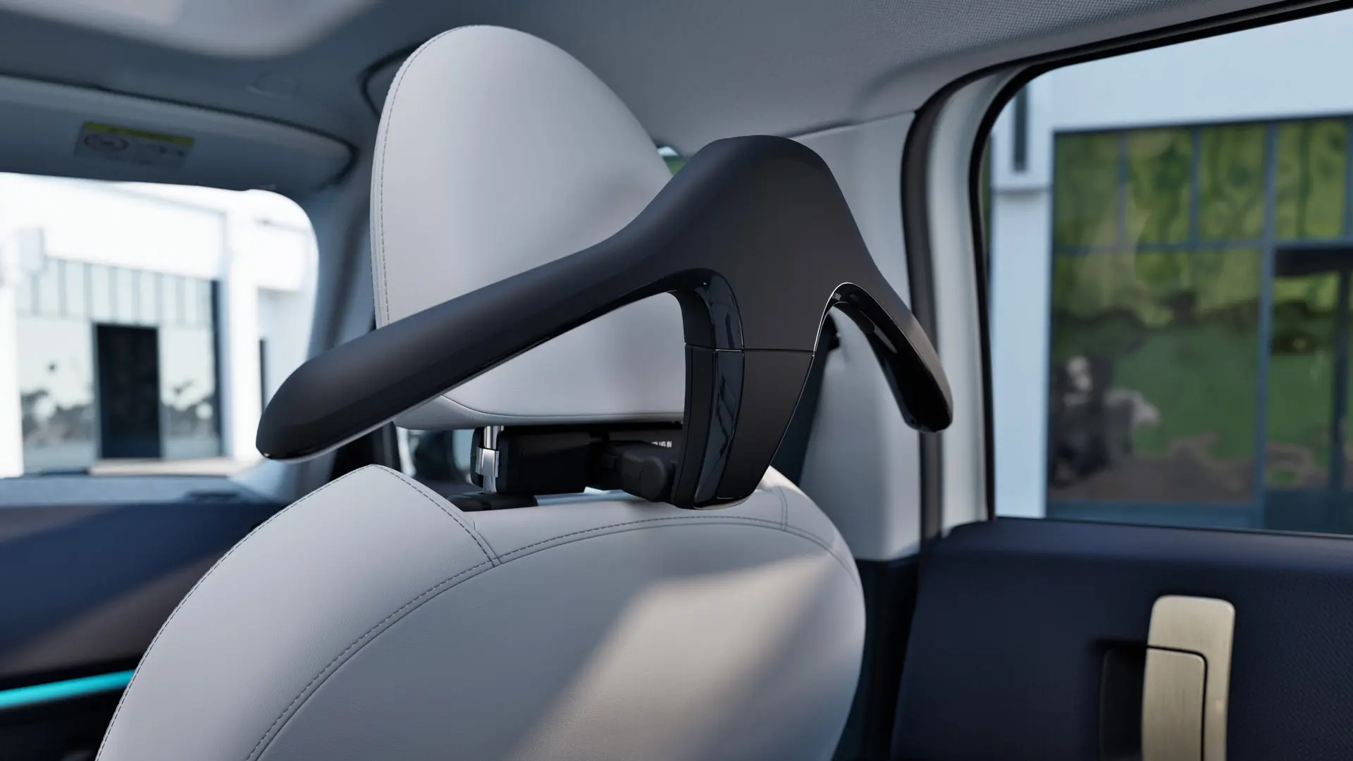 MINI Travel & Comfort System drabužių pakaba, pritvirtinta prie automobilio sėdynės galvos atramos.