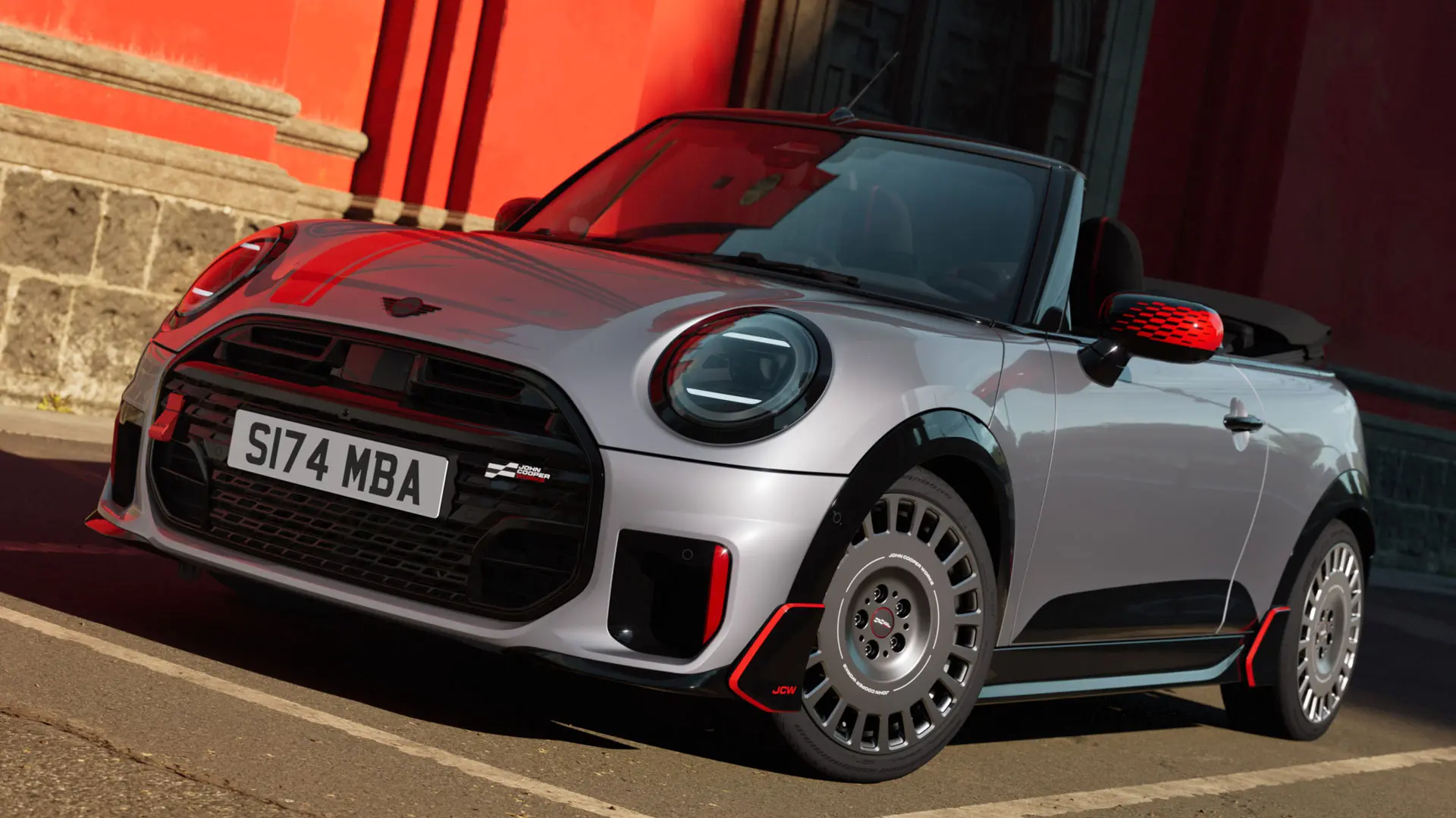 Sidabro spalvos MINI kabrioletas pasižymi sportišku JCW stiliumi – MINI JCW veidrodėlių korpusai, sportinės juostos ir aerodinaminiai kėbulo elementai.