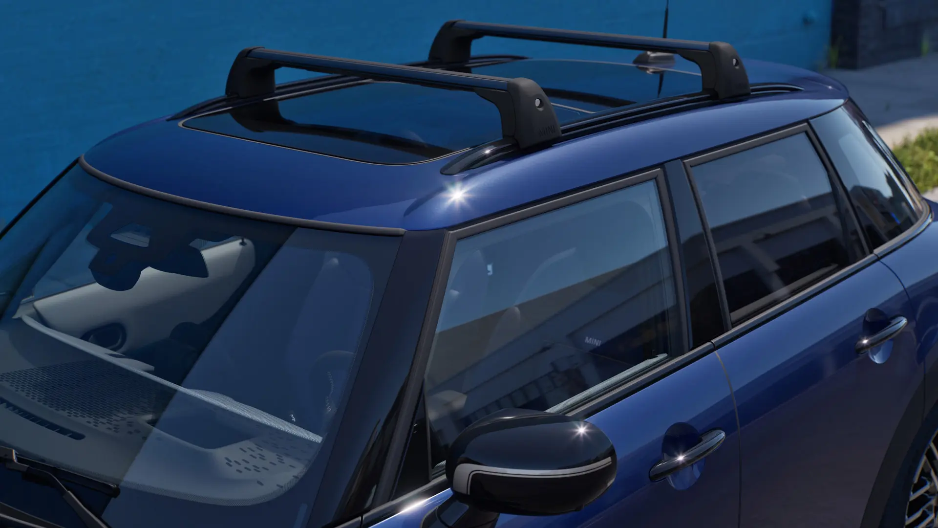 Mėlynos Indigo Sunset Blues spalvos MINI Aceman priekinis vaizdas iš šono su MINI stogo bagažine.