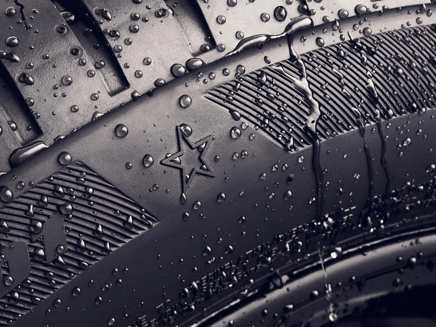 Priartintas padangos šono, ant kurio  matomas ženklinimas žvaigždute, reiškiantis, kad padanga yra patvirtinta kaip optimaliai tinkama MINI automobiliams, vaizdas