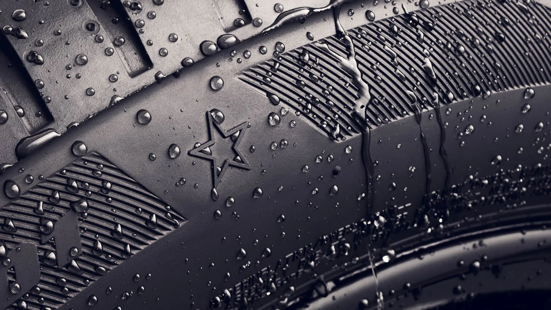 Priartintas padangos šono, ant kurio  matomas ženklinimas žvaigždute, reiškiantis, kad padanga yra patvirtinta kaip optimaliai tinkama MINI automobiliams, vaizdas